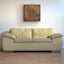 Beige sofa in a room with a textured wall art piece, a carved wood artwork of the Saudi Arabia map