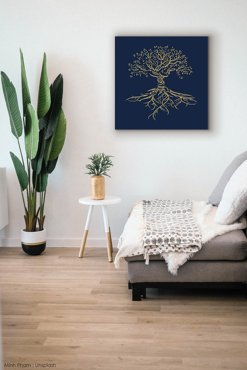 Wooden artwork of an olive tree with the Arabic phrase “The land is ours, and to it we return.” in a living room.