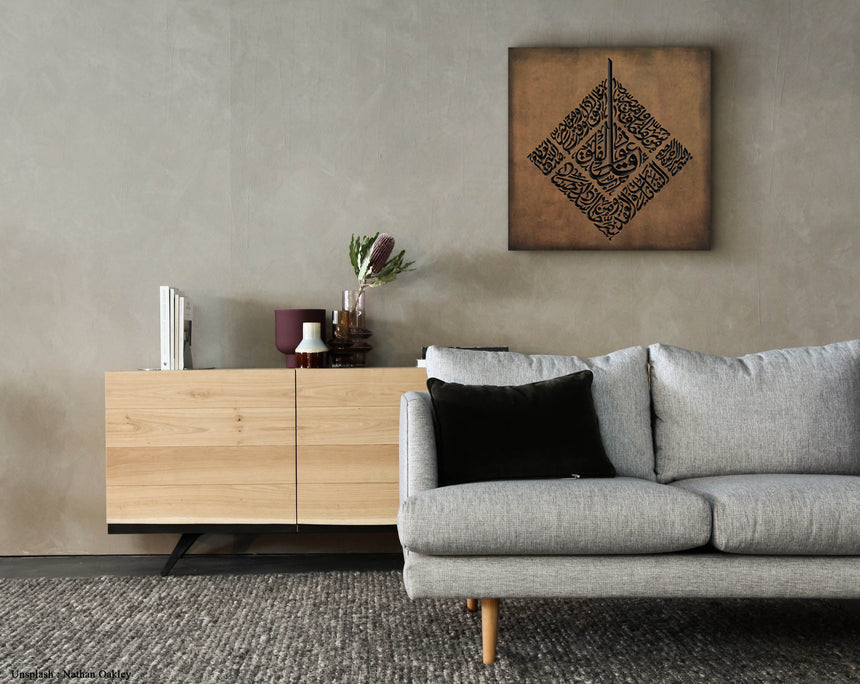 Carved wooden artwork of Surah Al-Falaq in a living room.