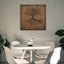 Wooden artwork of an olive tree with the Arabic phrase “The land is ours, and to it we return.” in a living room.