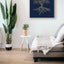 Wooden artwork of an olive tree with the Arabic phrase “The land is ours, and to it we return.” in a living room.