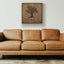 Wooden artwork of an olive tree with the quote “We will remain as long as thyme and olives remain.”  in a living room
