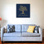 Wooden artwork of an olive tree with the quote “We will remain as long as thyme and olives remain.”  in a living room