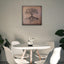 Wooden artwork of an olive tree with the Arabic phrase “The land is ours, and to it we return.” in a living room.